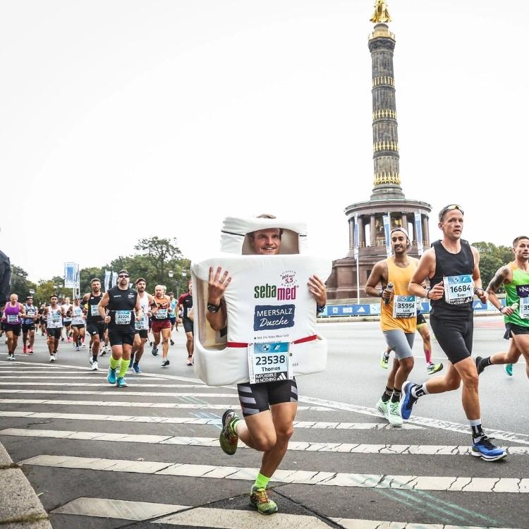 Läufer in einem Duschgel-Kostüm beim Berlin-Marathon vor dem Siegesdenkmal.