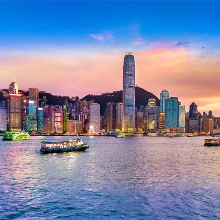 Skyline von Hongkong mit Booten auf dem Wasser bei Sonnenuntergang