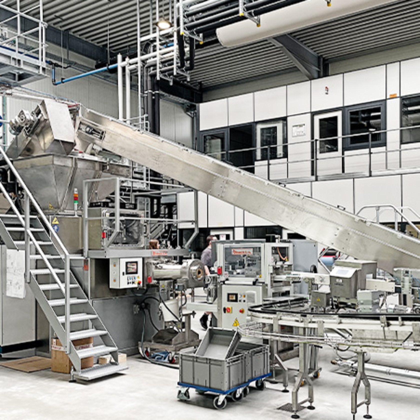 Fabrik mit Förderband und Produktionsanlagen in einer Halle