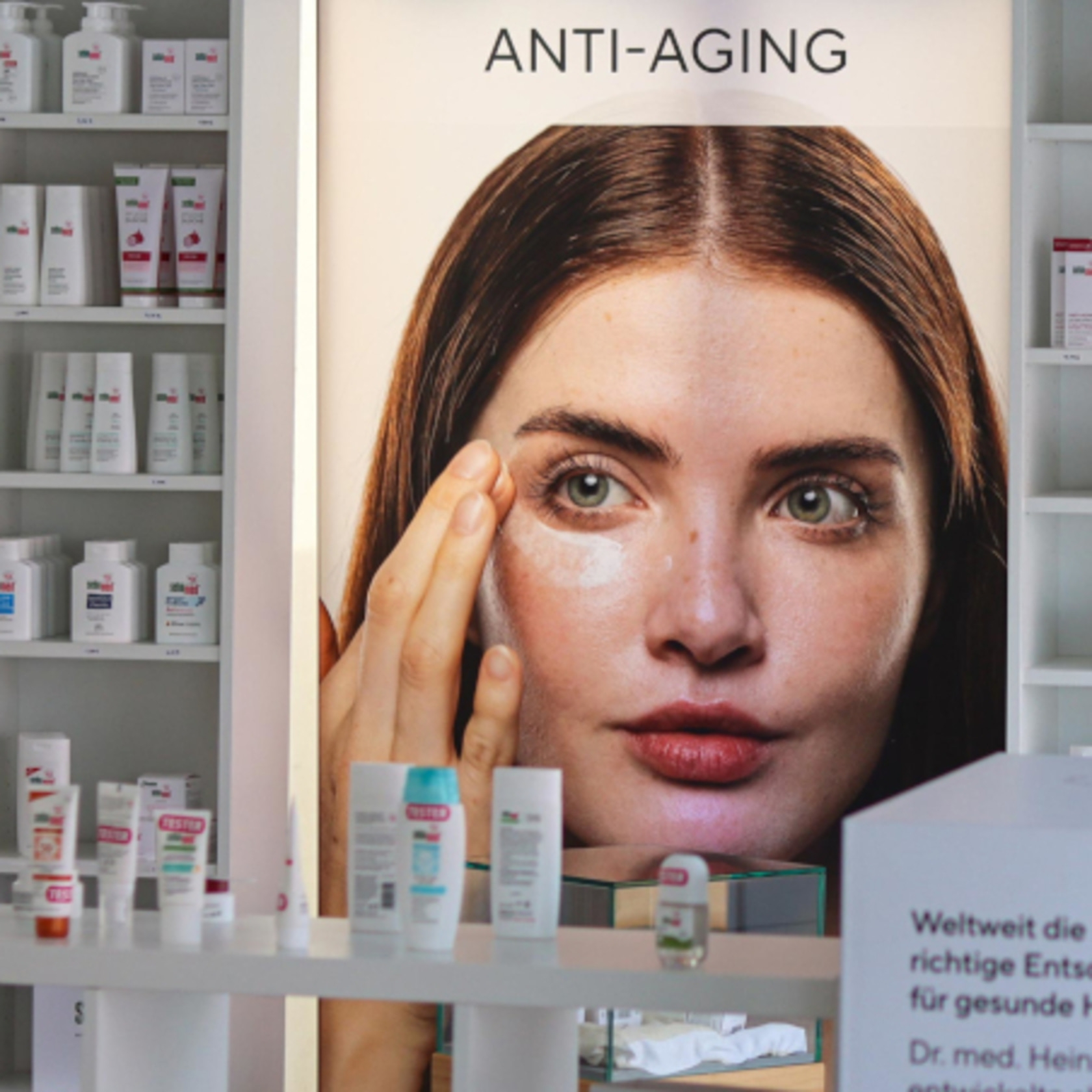 Anti-Aging-Werbung mit Frau, Produkten und Text. Schönheitspflege im Geschäft.