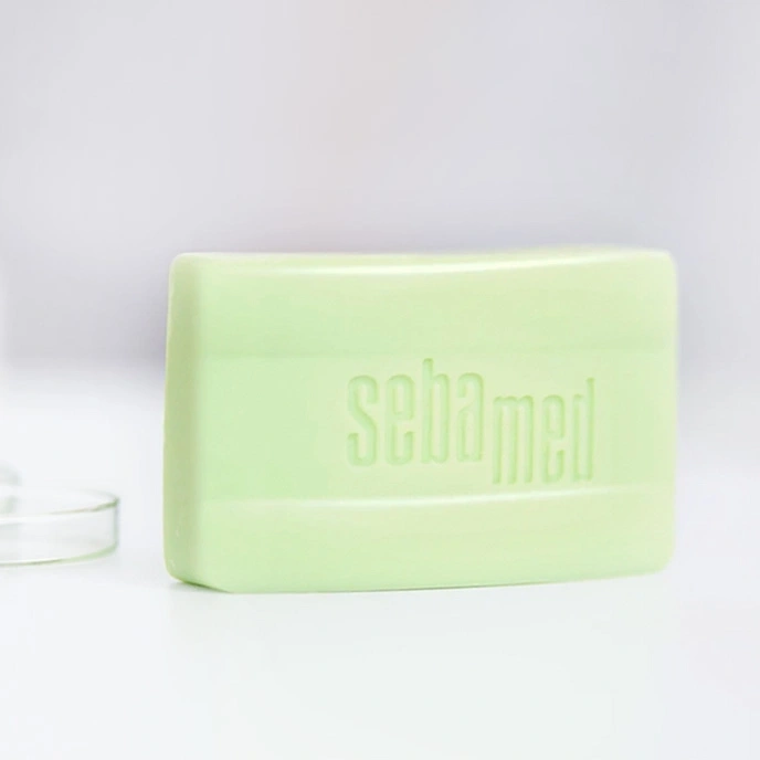 Ein grünes Stück Seife mit dem Wort 'sebamed' darauf.