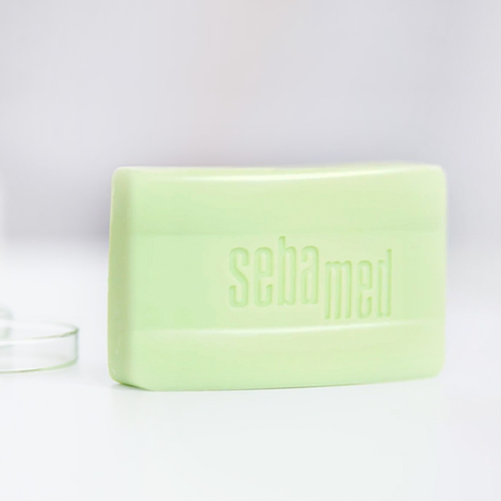 Ein grünes Stück Seife mit dem Wort 'sebamed' darauf.