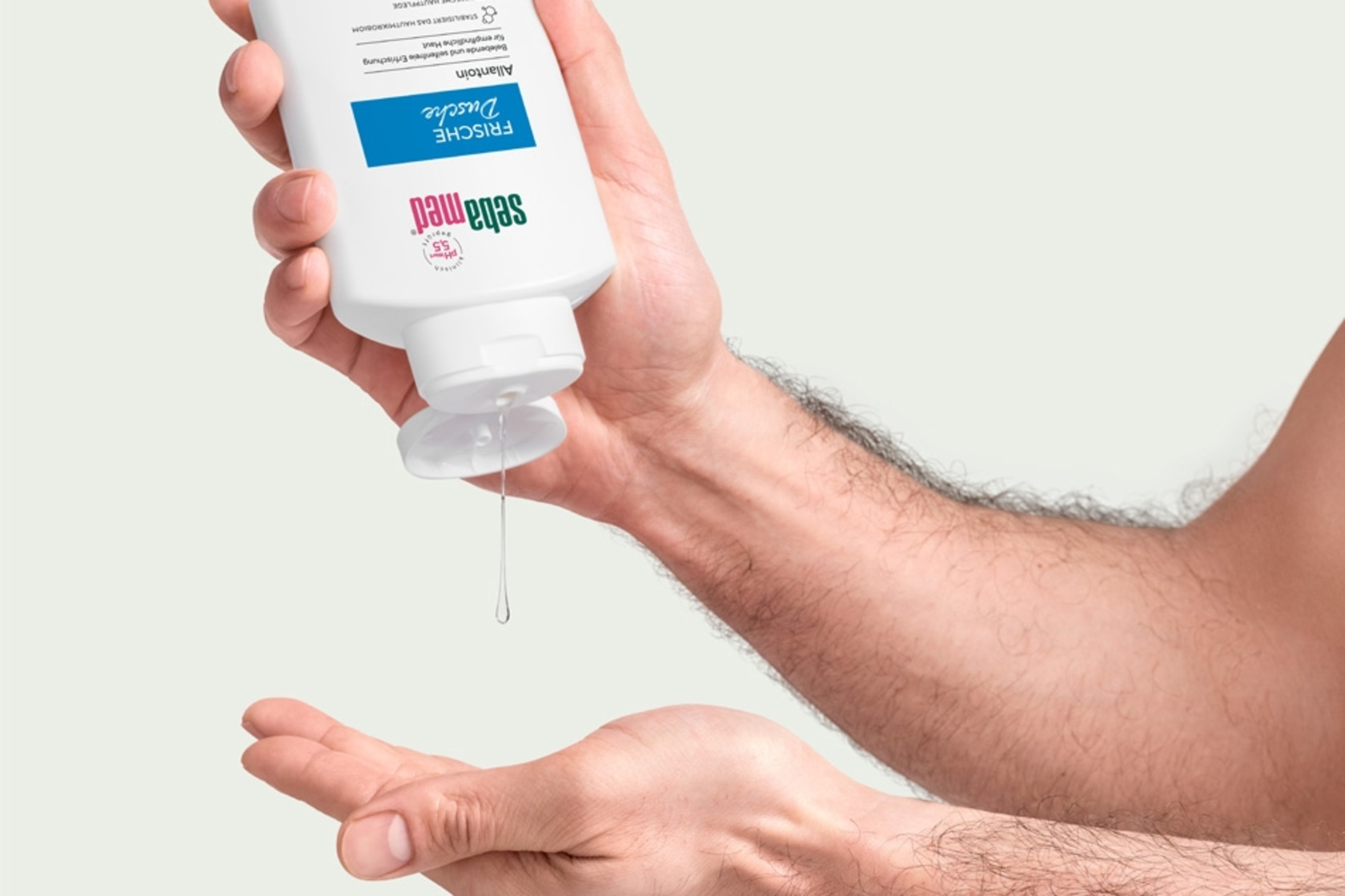 Person gießt Flüssigkeit aus einer Flasche in die Hand, Hautpflegeprodukt.