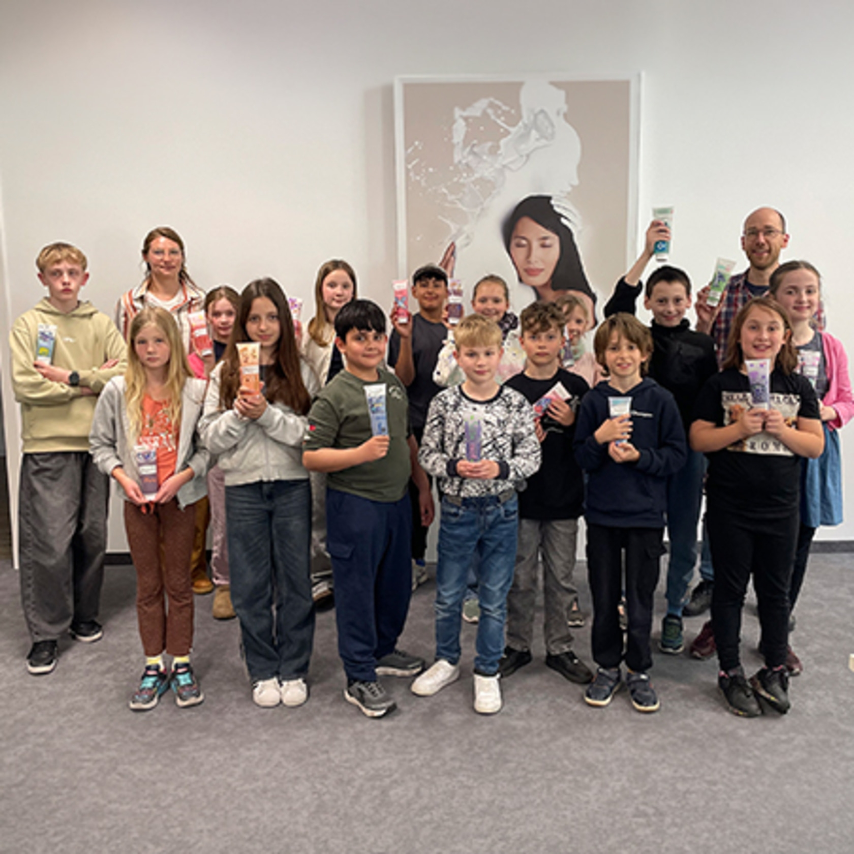 Eine Gruppe von Kindern und Erwachsenen hält Tuben mit Kosmetikprodukten.